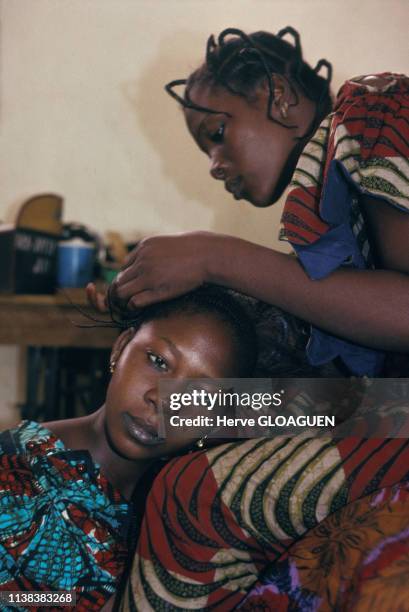 Une femme tresse les cheveux d'une jeune fille au Niger.