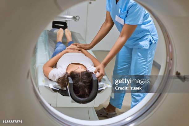 female nurse preparing patient for mri scan - radiotherapy stock pictures, royalty-free photos & images