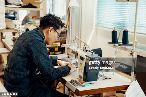 mitteler erwachsener schneider, der an einer nähmaschine in seinem designstudio arbeitet - präfektur okayama stock-fotos und bilder