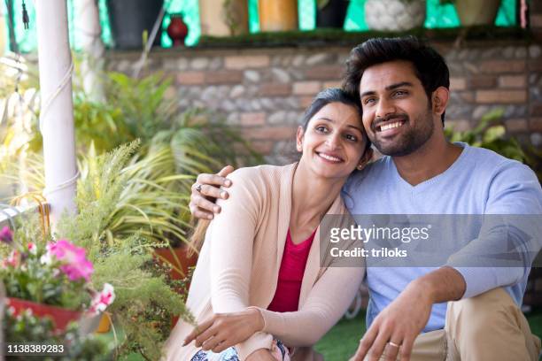 indian couple sitting on porch - couple stock pictures, royalty-free photos & images