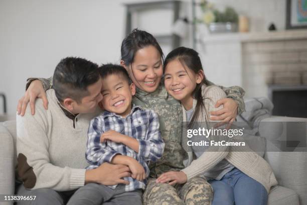 military family sitting on couch - military families stock pictures, royalty-free photos & images