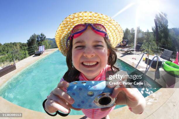 child on holiday next to pool with camera - fotolächeln stock-fotos und bilder