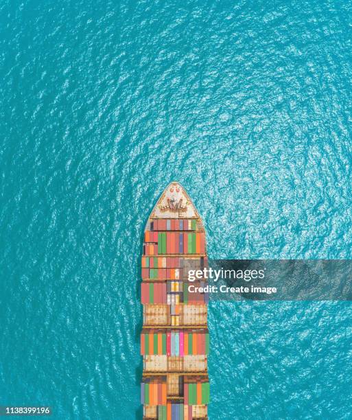 aerial top view container ship on the blue sea delivering container for logistics, import export, shipping or transportation. - shipping container top view - fotografias e filmes do acervo