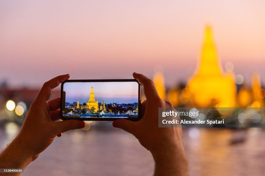 Photographing Wat Arun temple at sunset with smartphone