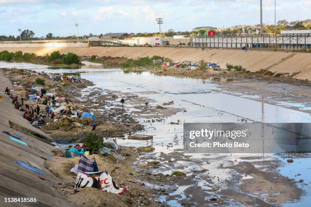 dozens of migrants live in extreme poverty along the tijuana canal in baja california near the us-mexico border - tijuana mexico stock pictures, royalty-free photos & images