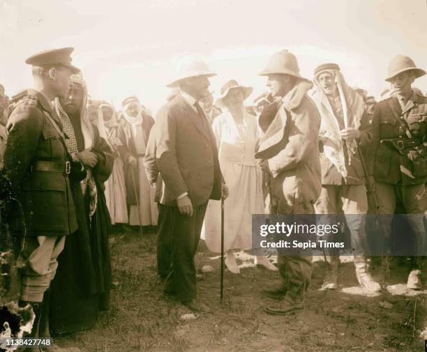 Pilot in flight suit greets Sir Herbert Samuel. Gertrude Bell stands between Samuel and pilot. Wyndham Deedes and Amir Abdullah to the left in...