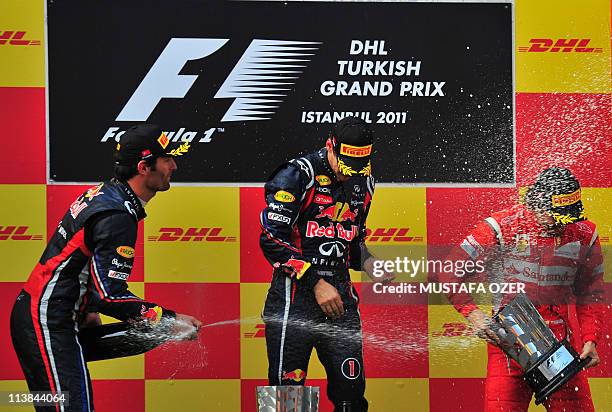 Red Bull Racing's Australian driver Mark Webber , Red Bull Racing's German driver Sebastian Vettel and Ferrari's Spanish driver Fernando Alonso spray...