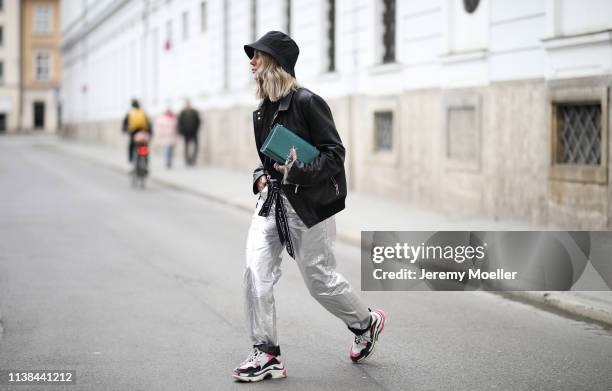 Karin Teigl wearing Isabel Marant pants, Balenciaga Triple S sneaker, Christian Dior belt, Saint Laurent bag, andotherstories hat and Dior jacket on...