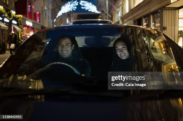 smiling couple driving car at night - husband stock pictures, royalty-free photos & images