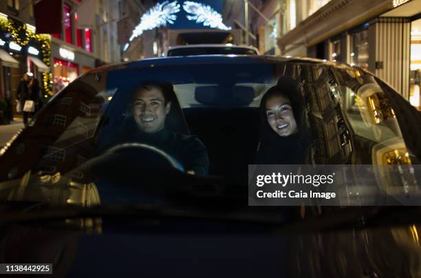smiling couple driving car at night - the japanese wife - fotografias e filmes do acervo