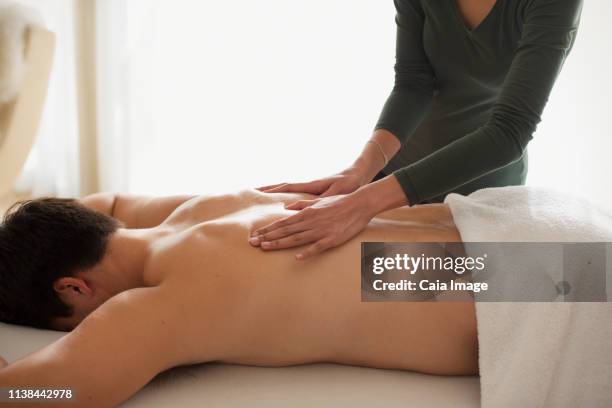 man receiving back massage - masseuse stock pictures, royalty-free photos & images