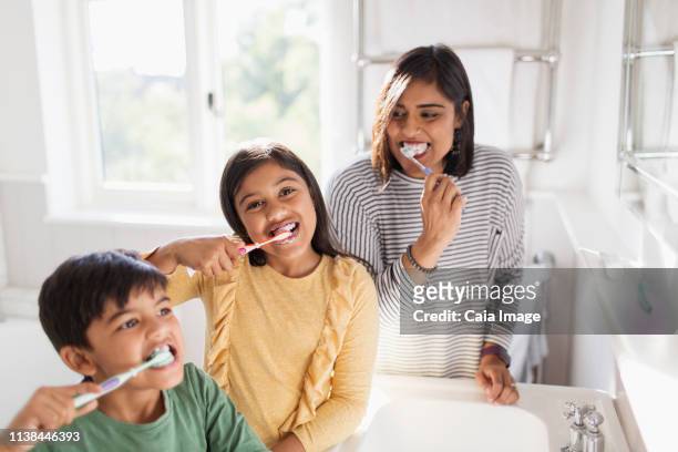 portrait happy family brushing teeth in bathroom - brothers bathroom stock-fotos und bilder