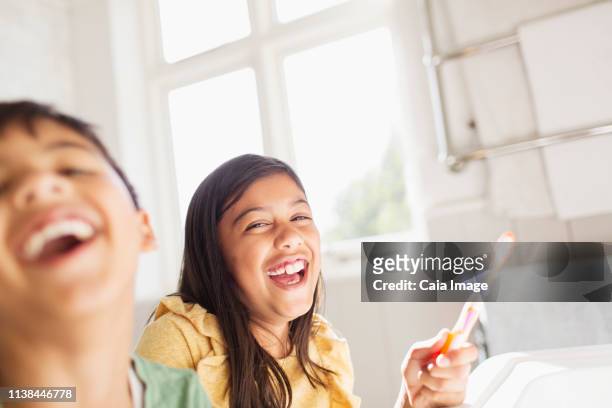 portrait laughing brother and sister brushing teeth in bathroom - brothers bathroom stock-fotos und bilder