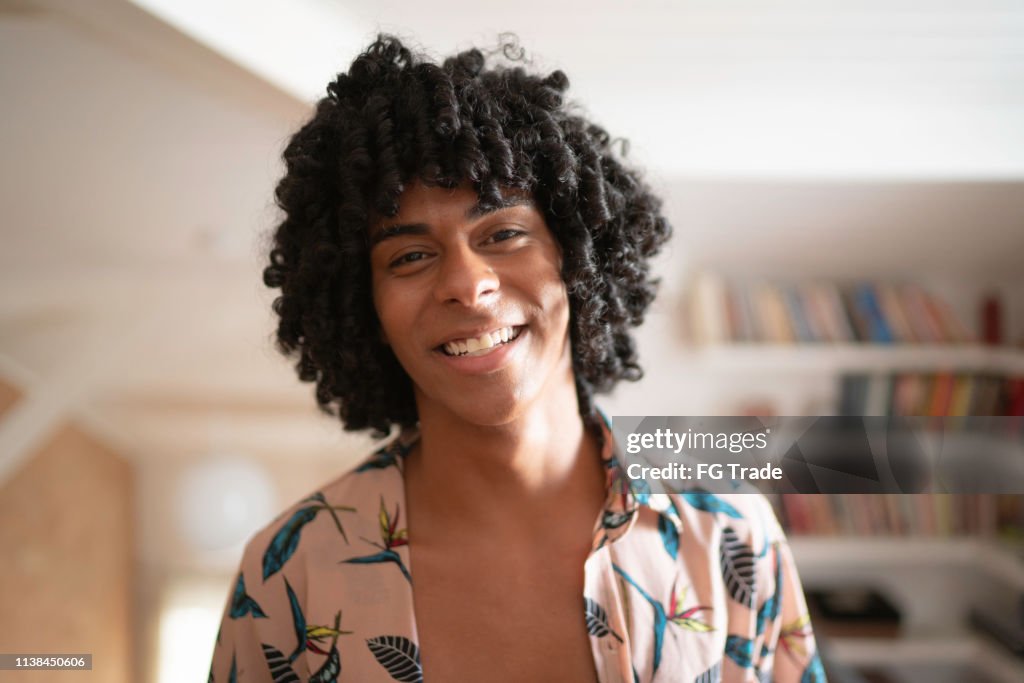 Young man laughing at home