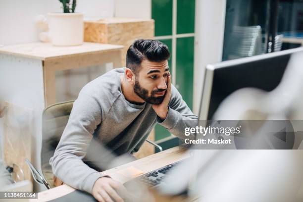 high angle view of exhausted businessman using computer on desk while sitting in office - boredom stock pictures, royalty-free photos & images