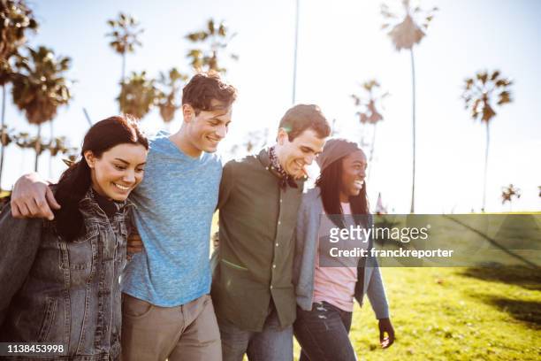 friends walking all together on venice beach - arm in arm stock pictures, royalty-free photos & images