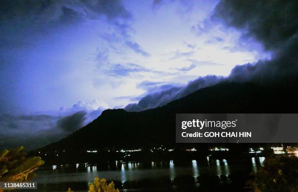 This picture taken of April 4 2019 shows a storm approaching the resort town of Parapat on Indonesia's Lake Toba, which covers some 1,707 square...