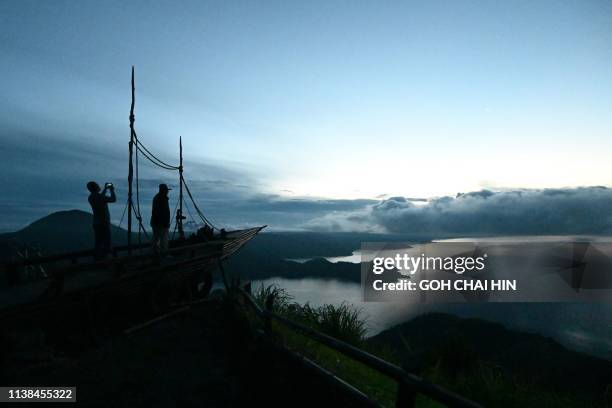 This picture taken of April 3, 2019 shows visitors enjoying the view of Indonesia's Lake Toba, from Kabanjahe, which covers some 1,707 square...