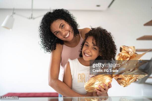 mother and daughter celebrating easter at home portrait - easter egg chocolate stock pictures, royalty-free photos & images