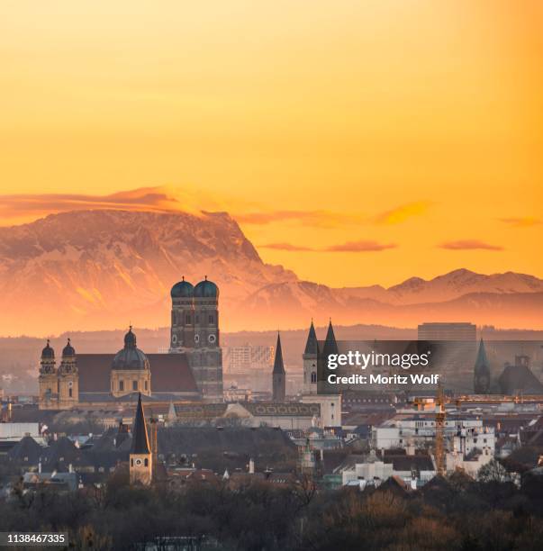 view over munich with church of our lady, theatine church, ludwigskirche, behind zugspitze at sunset, munich, bavaria, germany - catedral de múnich fotografías e imágenes de stock