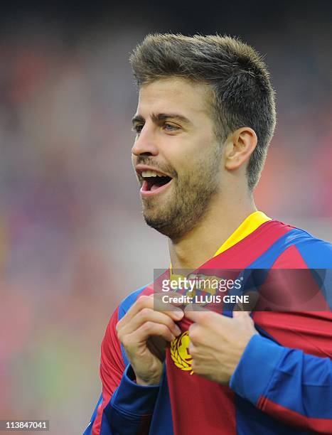 Barcelona's defender Gerard Pique celebrates after scoring a goal during the Spanish League football match between Barcelona and Espanyol at the Nou...