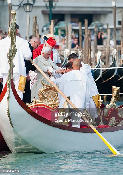 Gondoliers help Pope Benedict XVI aboard the Dogaressa gondola in St. Mark's basin on May 8, 2011 in Venice, Italy. Pope Benedict XVI is visiting...
