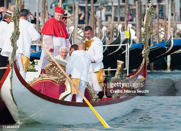 Gondoliers help Pope Benedict XVI aboard the Dogaressa gondola in St. Mark's basin on May 8, 2011 in Venice, Italy. Pope Benedict XVI is visiting...