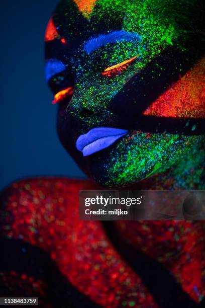 uma mulher pintada com fluorescente compõem - fluorescente - fotografias e filmes do acervo