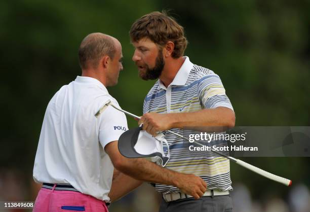 Lucas Glover shakes hands with Jonathan Byrd on the 18th green after defeating Byrd on the first playoff hole during the final round of the Wells...