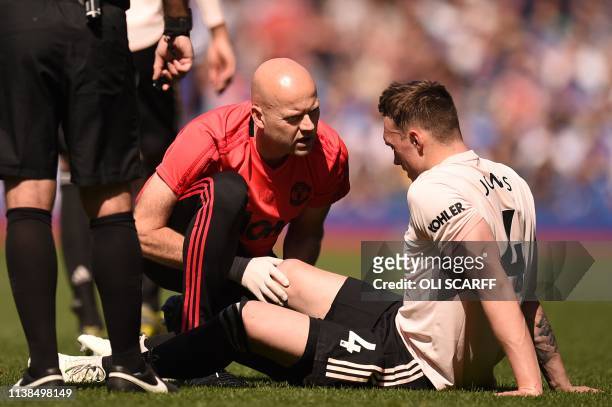 Manchester United's English defender Phil Jones is treated for an injury during the English Premier League football match between Everton and...