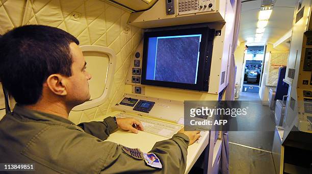 Technician member of the crew of a Brazilian R-99 Air Force radar plane analyzes images on a screen at the Recife's airport on June 05 after a search...
