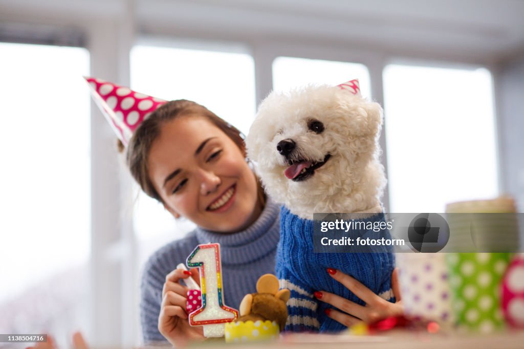 Girl and her dog celebrating dog's first birthday