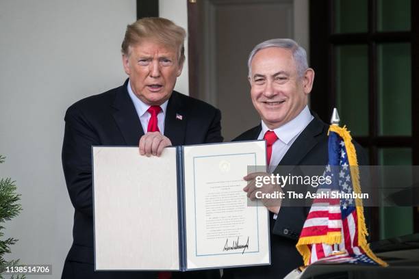 President Donald Trump and Prime Minister of Israel Benjamin Netanyahu show members of the media the proclamation Trump signed on recognizing...