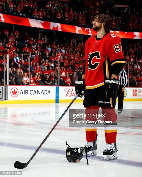 Michael Frolik of the Calgary Flames stands for the national anthems before the start of an NHL game where the Calgary Flames hosted the Los Angeles...
