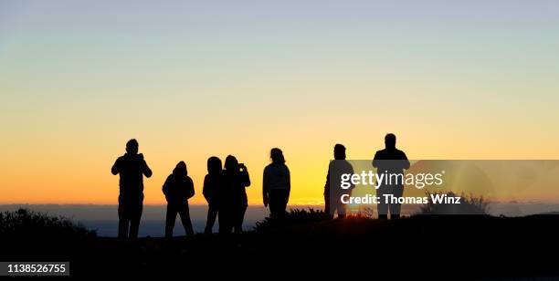 people watching the sunset at big sur - think big stockfoto's en -beelden
