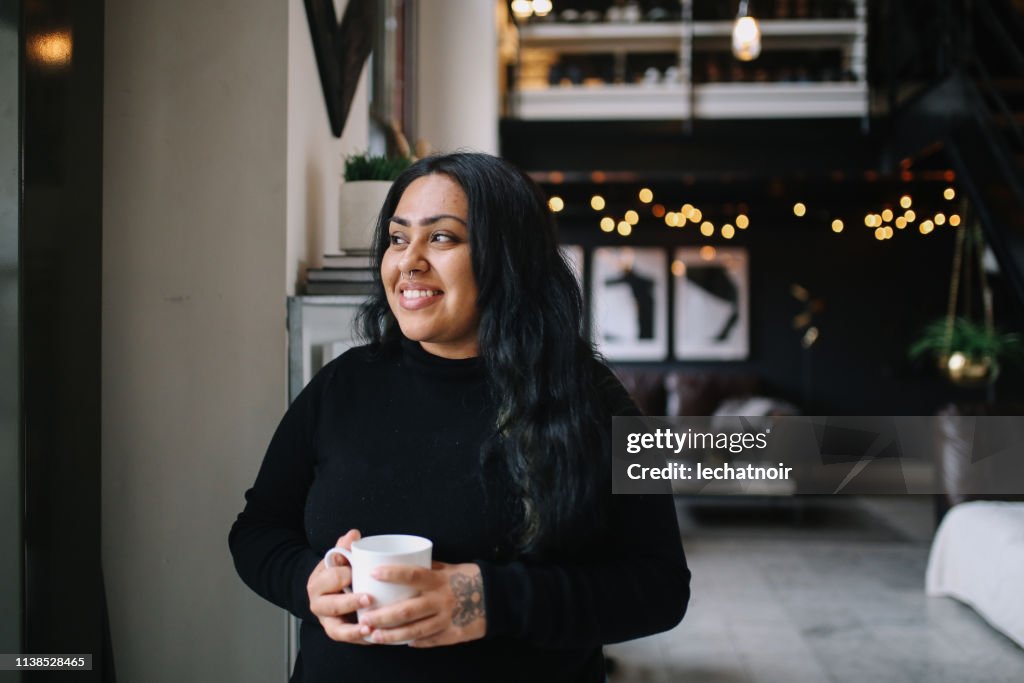 Portrait of a young woman having coffee in her Downtown Los Angeles apartment