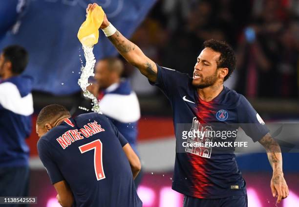 Paris Saint-Germain's Brazilian forward Neymar empties a water pouch on Paris Saint-Germain's French forward Kylian Mbappe as they celebrate after...