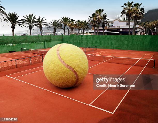 oversized ball on an outdoor tennis court - larger than life stock pictures, royalty-free photos & images