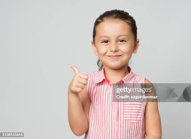 little girl giving thumbs up - girls on white background stock pictures, royalty-free photos & images