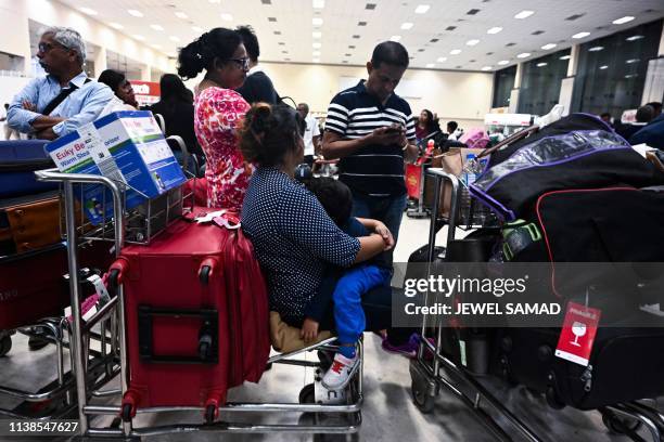 Passengers wait inside the arrival hall at Bandaranaike International Airport in Katunayake on April 22 after authorities imposed a curfew following...