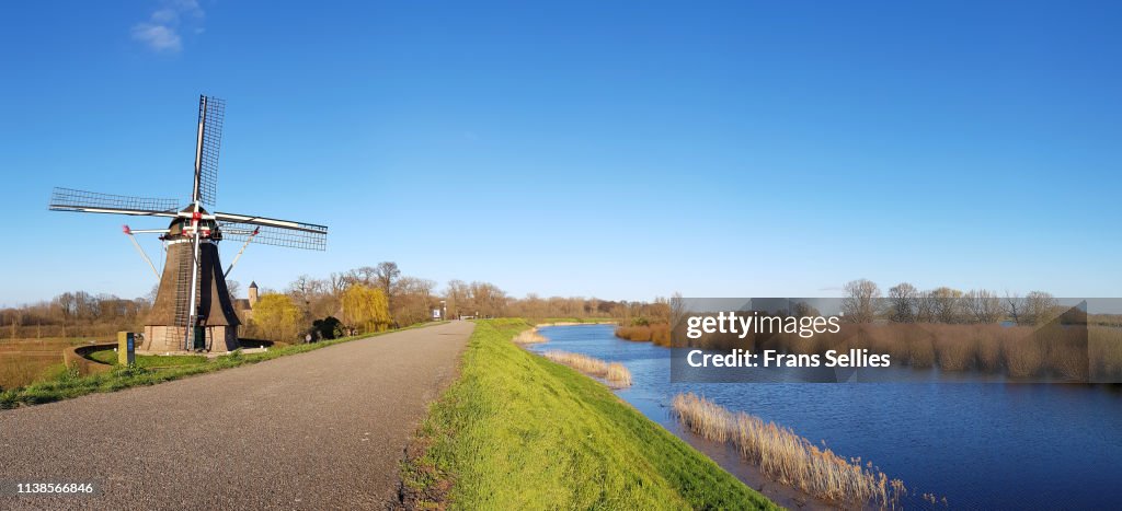 Landscape with windmill, dyke and river foreland, the Netherlands