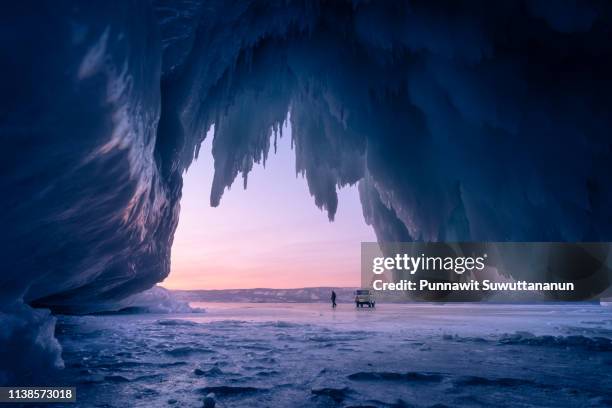 ice cave in baikal frozen lake in winter season at beautiful sunset, olkhon island, siberia, russia - lake baikal stockfoto's en -beelden