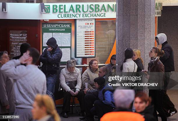 People wait in front of a currency exchange office in Minsk on May 4 to buy hard currency after a devaluation of the Belarus ruble. Belarus has...