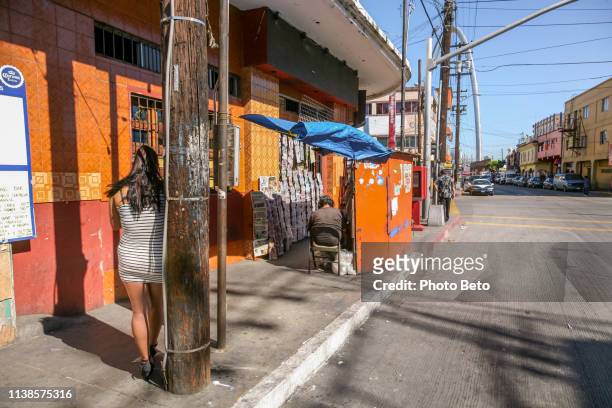 a prostitute along a street in the red light district of tijuana in baja california near the us-mexico border - streetwalker stock pictures, royalty-free photos & images
