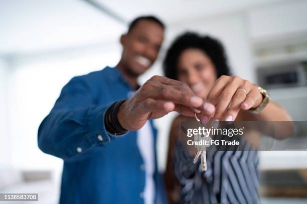 latijns koppel dat de sleutels van hun nieuwe huis houdt - home key stockfoto's en -beelden