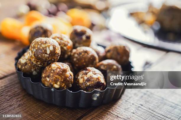 gesunde energiebälle aus trockenfrüchten und nüssen - protein balls stock-fotos und bilder