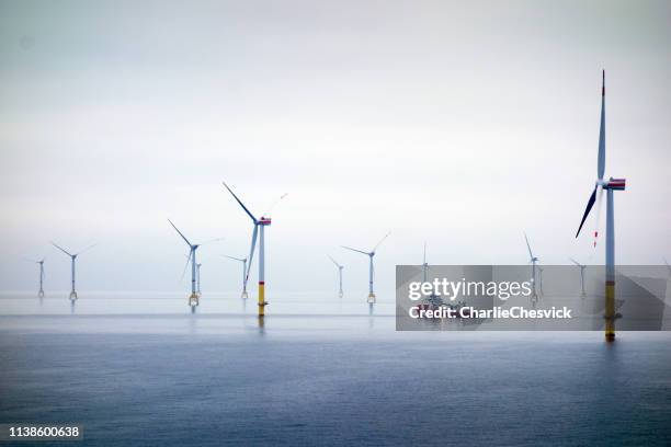 grande ferme éolienne offshore avec navire de transfert - wind stock photos et images de collection