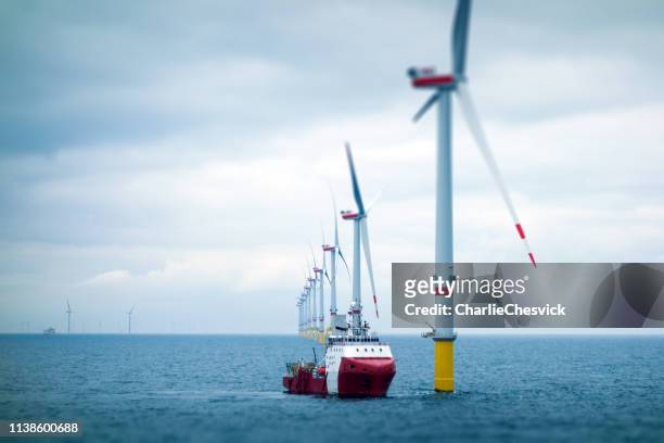 grande ferme éolienne offshore avec navire de transfert - air photos et images de collection