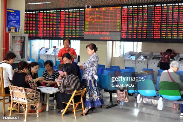 Investors play poker at a stock exchange hall on May 9, 2011 in Shanghai, China. The power companies and train markers led Chinese stocks rebounding...