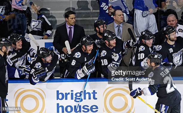 Steven Stamkos, Ryan Malone, Adam Hall, and Sean Bergenheim of the Tampa Bay Lightning cheers on teammate Martin St. Louis from the bench against the...